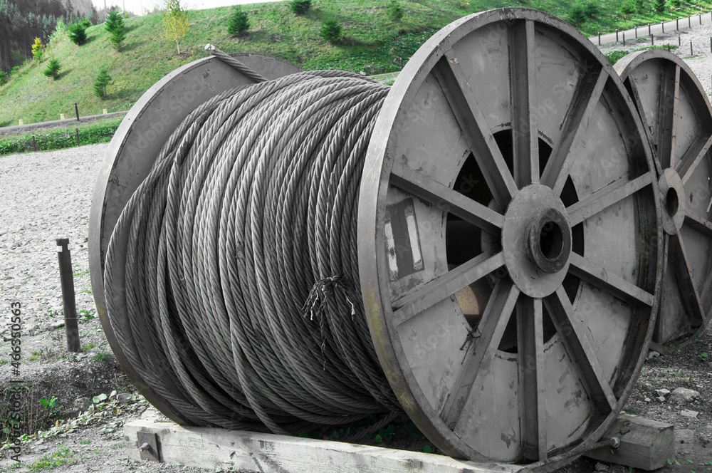 bobbin with an iron rope. strength concept. the cord is wound on a large spool. string twisted on a drum bobbin with an iron rope. strength concept. the cord is wound on a large spool. string twisted on a drum