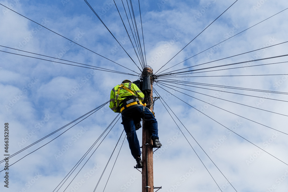Telecommunications, telecom engineer at work on the top of a telegraph pole - obrazy, fototapety, plakaty 