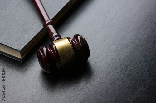 Law concept - Open law book with a wooden judges gavel on table in a courtroom or law enforcement office isolated on white background. Copy space for text.