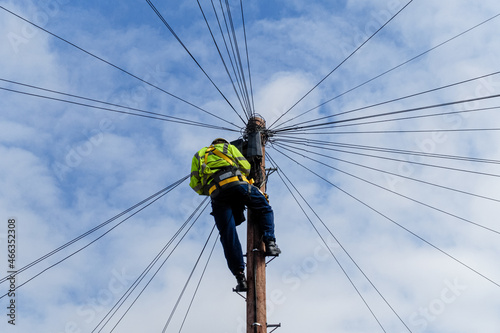 Telecommunications, telecom engineer at work on the top of a telegraph pole © Marcin Rogozinski