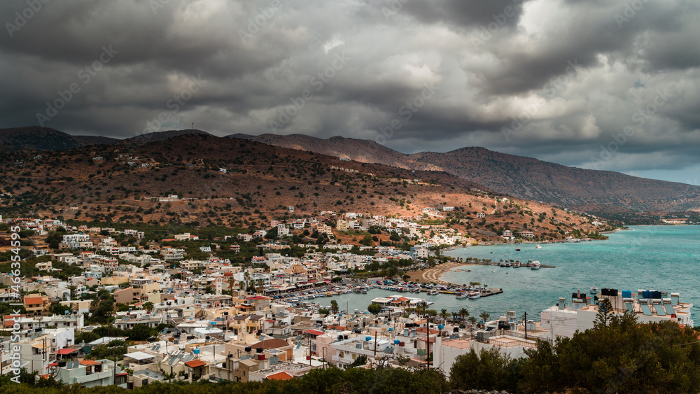 Stormy clouds and bands of rain over the Greek tourist resort town of Elounda on the island of Crete