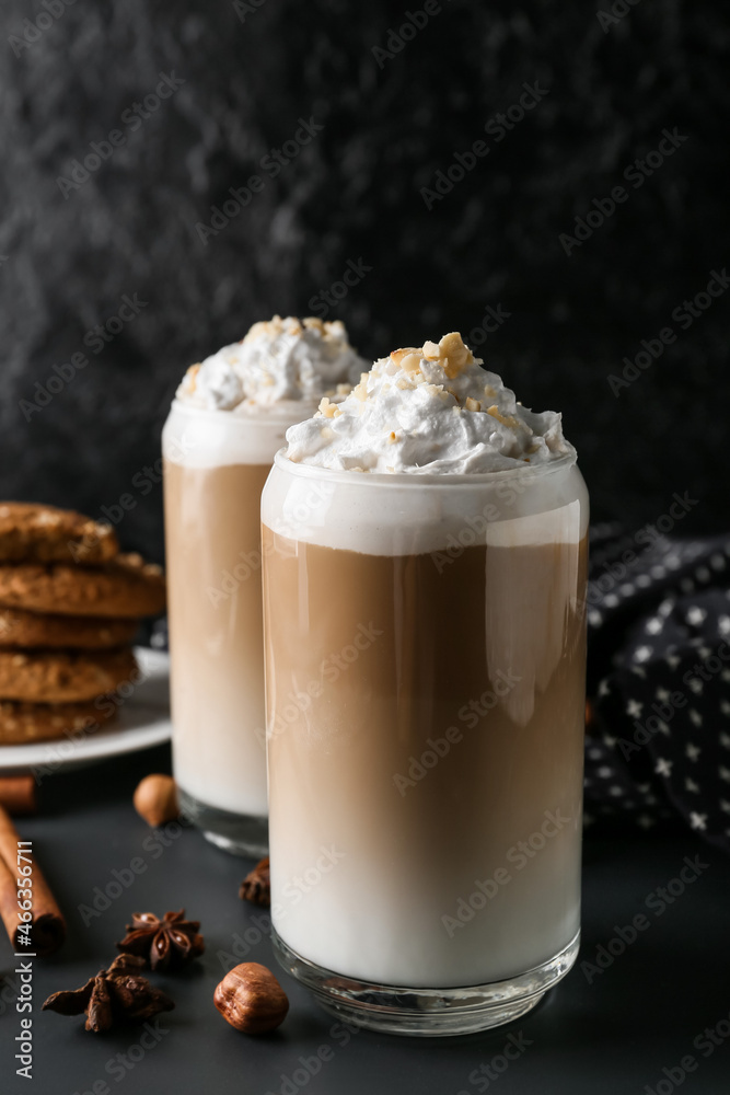 Glasses of tasty latte with nuts on black background Glasses of tasty latte with nuts on black background
