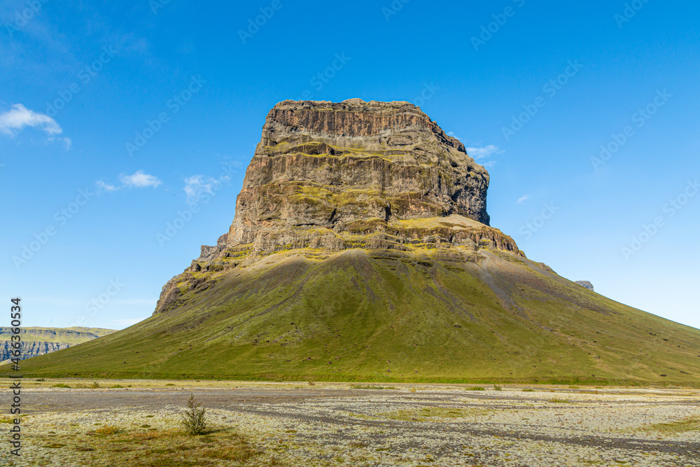 Butte rock formation with blue sky in southern Iceland. Copy space in sky.