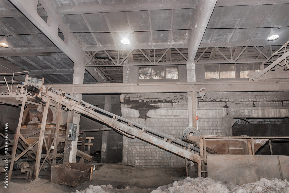 Old conveyor belt in the industrial workshop of the plant or enterprise for the processing of sand, soil and land factory Old conveyor belt in the industrial workshop of the plant or enterprise for the processing of sand, soil and land factory