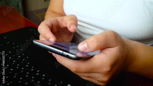 Girl using smartphone close up sliding screen, pressing with finger, surfing internet, social media, shopping online, typing text. Chatting, communicating and play via mobile phone in two hands