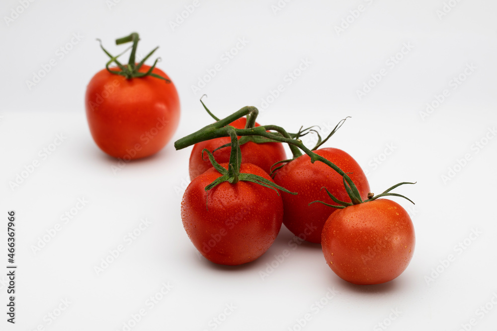 Red tomatoes with water drops on white background