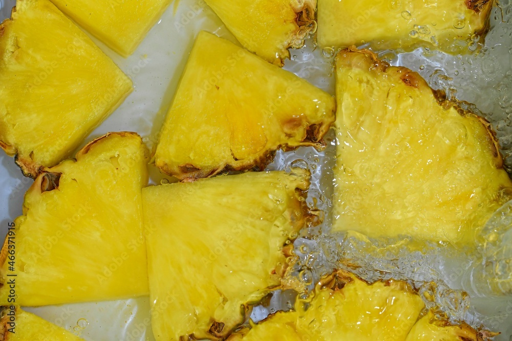 Slices of pineapple in water on white background. Pineapple close-up in liquid with bubbles. Slices of ripe pineapple in water. Macro image of fruits in water Slices of pineapple in water on white background. Pineapple close-up in liquid with bubbles. Slices of ripe pineapple in water. Macro image of fruits in water