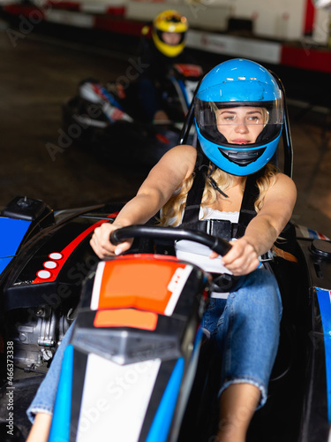 Glad positive woman driving sport car for karting in a circuit lap in sport club