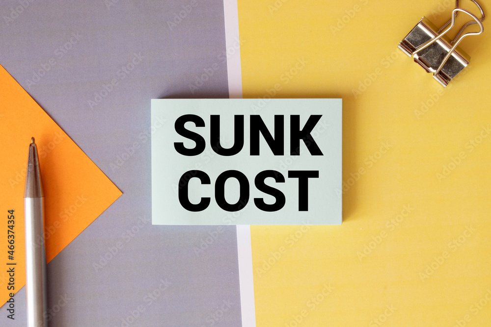 Obraz premium White paper card with text SUNK COST sheet of white paper for notes.