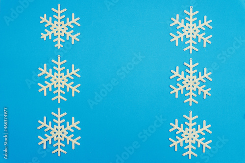 The Christmas composition, a group of white shiny snowflakes on a blue background, copy space. Festive, New Year's concept. Minimum style. Top View