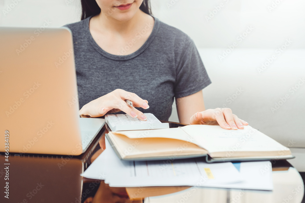 Woman using calculator Accounting Calculating Cost Economic bills saving money in home , finance concept Woman using calculator Accounting Calculating Cost Economic bills saving money in home , finance concept