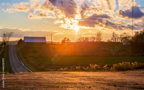 country side sunset with a barn and dirt road