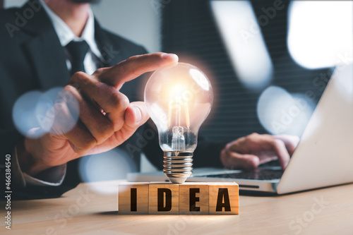 Businessman hand holding light bulbs and new ideas of business with innovative technology network connection.