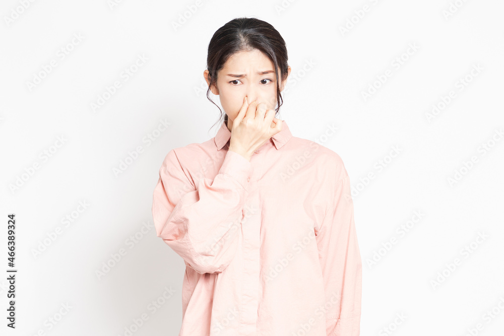匂いが臭くて鼻をつまむ女性