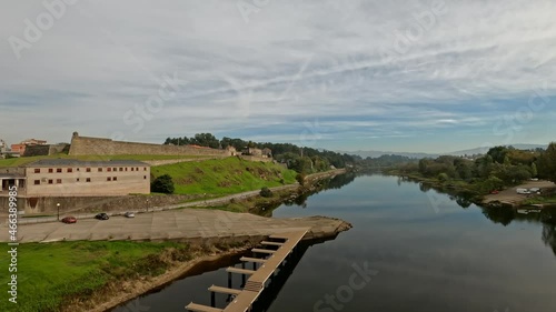 Traveling sideways on the Miño river over the international bridge from Salvaterra de Miño to Monçao with medieval Spanish fortress in the background on the left. photo