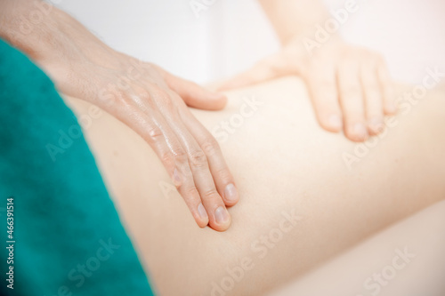 Medical massage of back young woman, closeup of hands of male doctor osteopath