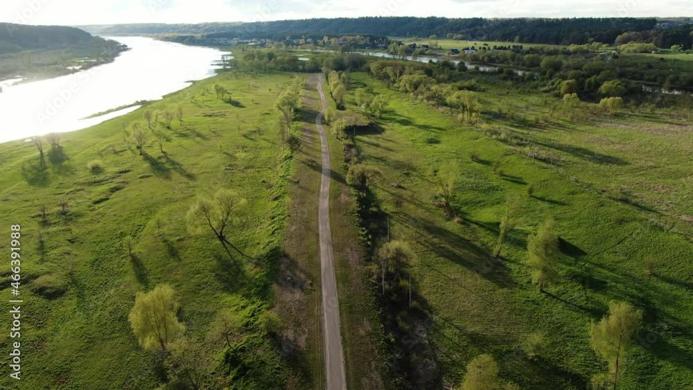Empty modern bicycle pathway in green landscape near river, aerial drone view