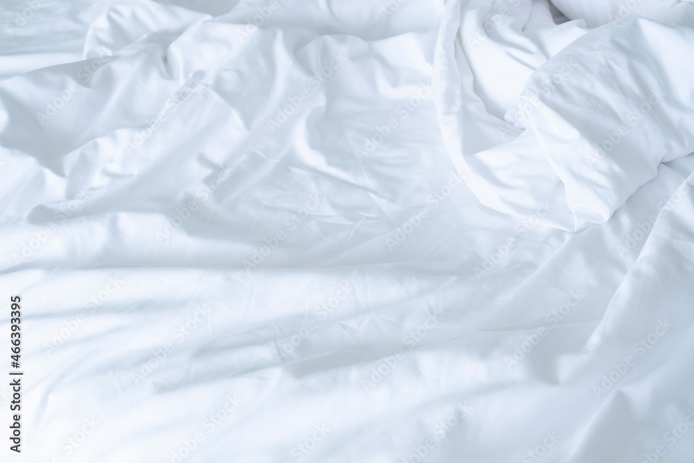 Obraz premium Close up messy Soft pillows on comfortable crumpled linen bed sheet in the hotel. Concept bed after sex night of new married couple or long relaxing weekend.
