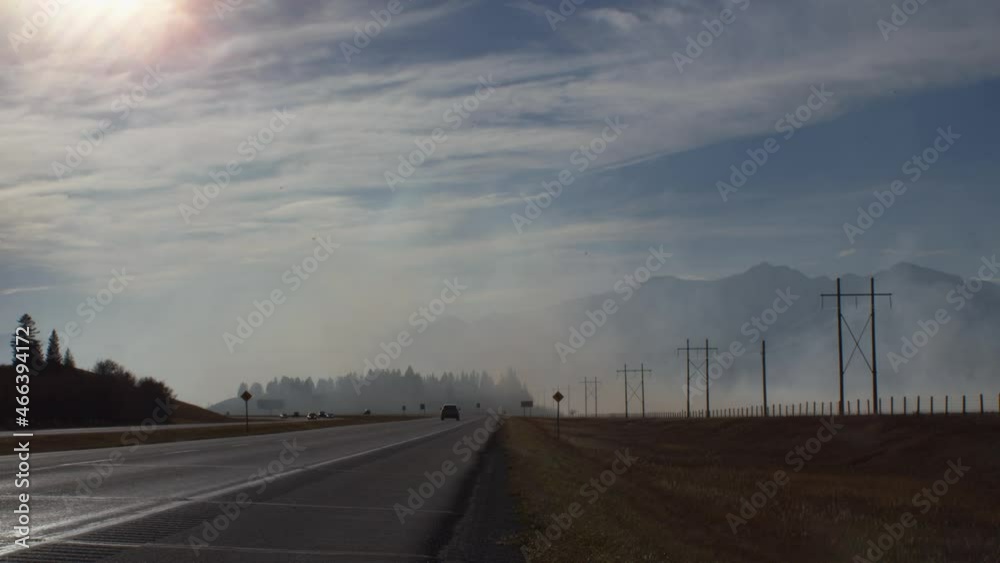 Highway with smoke from fire close to mountains Highway with smoke from fire close to mountains