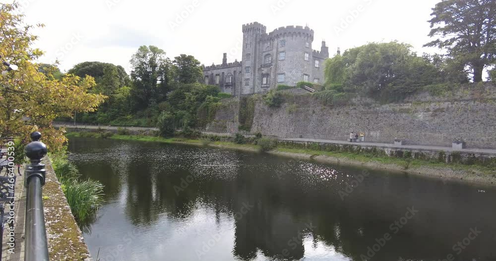 Panning right shot of Kilkenny Castle from the River Nore on a sunny day in Ireland Panning right shot of Kilkenny Castle from the River Nore on a sunny day in Ireland