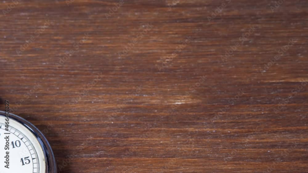 Old chronometer counts time on brown wooden background. Time start with analogue stopwatch. Sport or business concept Old chronometer counts time on brown wooden background. Time start with analogue stopwatch. Sport or business concept