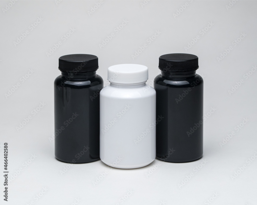 White and black plastic pill jars on a white background. Isolated White and black plastic pill jars on a white background. Isolated