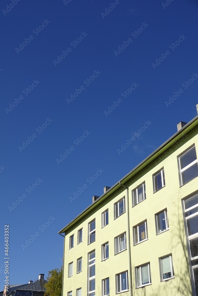 Close up of renovated yellow house facade with many windows. Clear blue sky background. Sunny day. Bottom up view. Pelgulinna, Tallinn, Estonia, Europe. September 2021 Close up of renovated yellow house facade with many windows. Clear blue sky background. Sunny day. Bottom up view. Pelgulinna, Tallinn, Estonia, Europe. September 2021