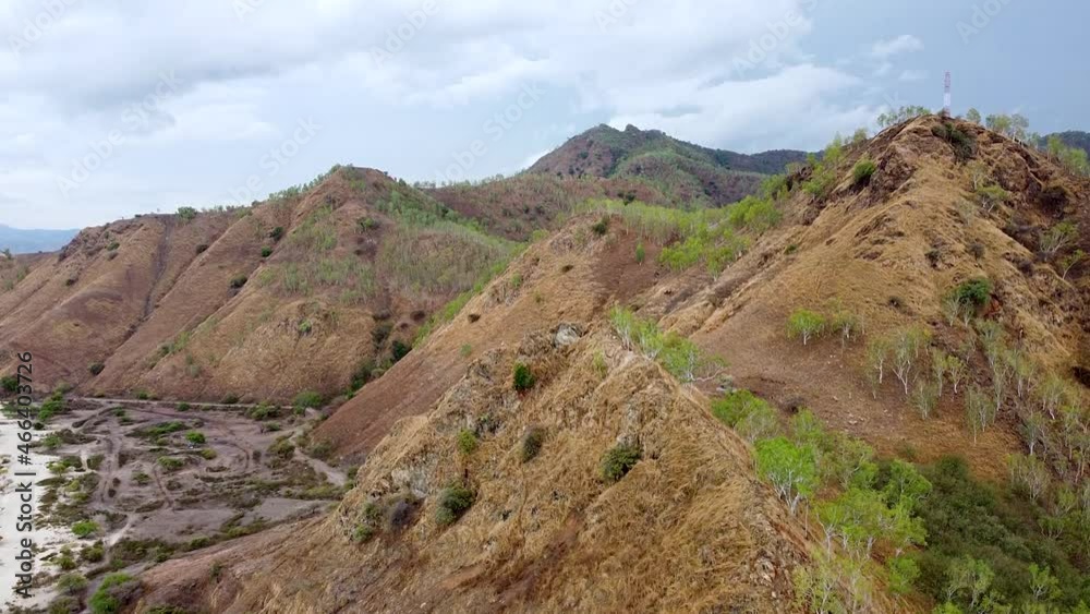 Aerial drone rising over dry season brown hill landscape with a telecommunications tower on top on tropical island Dili, Timor Leste, Southeast Asia Aerial drone rising over dry season brown hill landscape with a telecommunications tower on top on tropical island Dili, Timor Leste, Southeast Asia