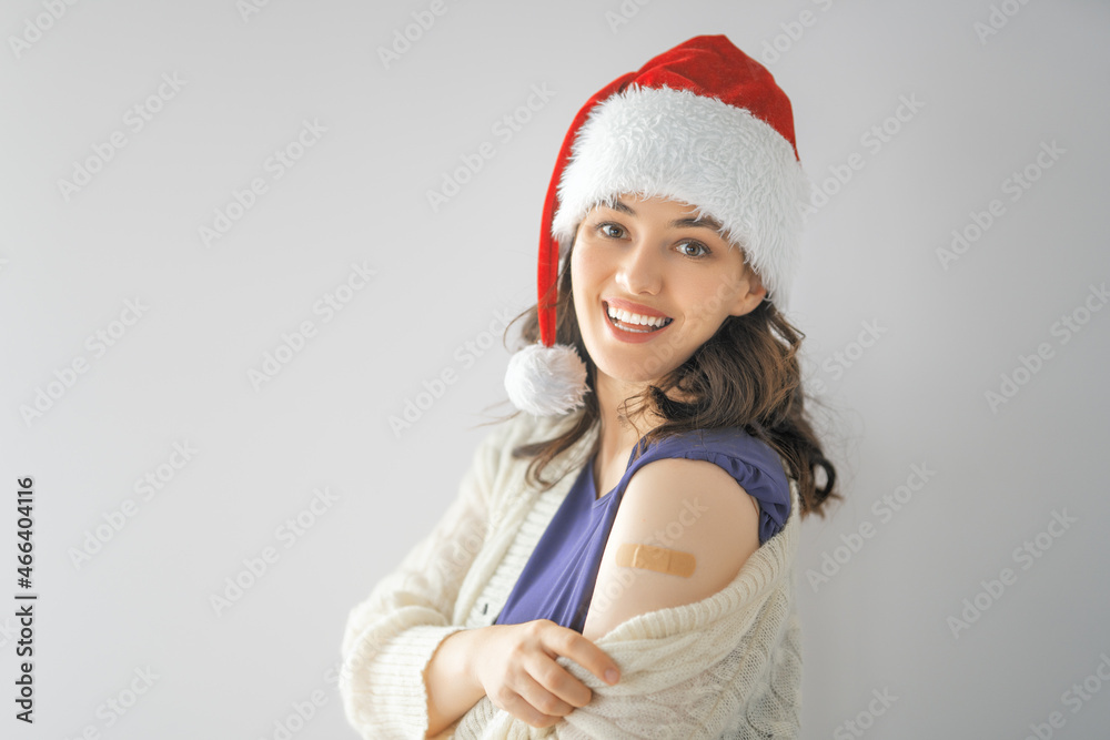 Young woman after vaccination wearing Santa hat Young woman after vaccination wearing Santa hat