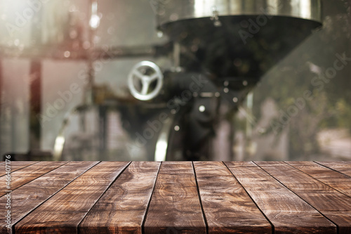 Empty wood table top and blurred coffee shop with coffee roaster interior background - can used for display or montage your products. photo