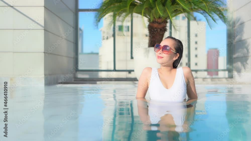 Asian woman in her 30th relaxing in luxury rooftop outdoor swimming pool at Bangkok city hotel Asian woman in her 30th relaxing in luxury rooftop outdoor swimming pool at Bangkok city hotel
