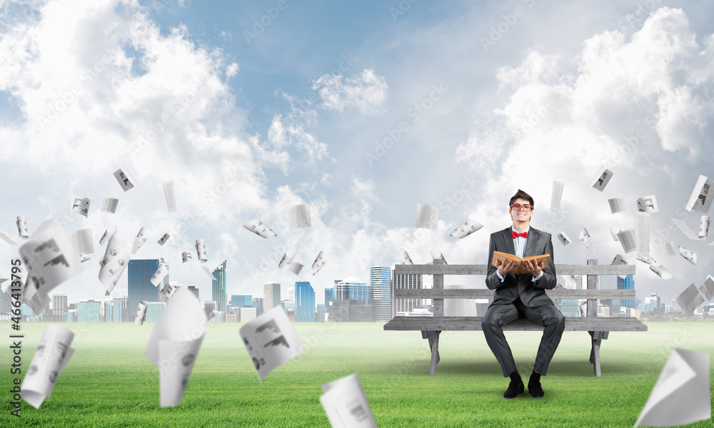 young student with a book on a bench