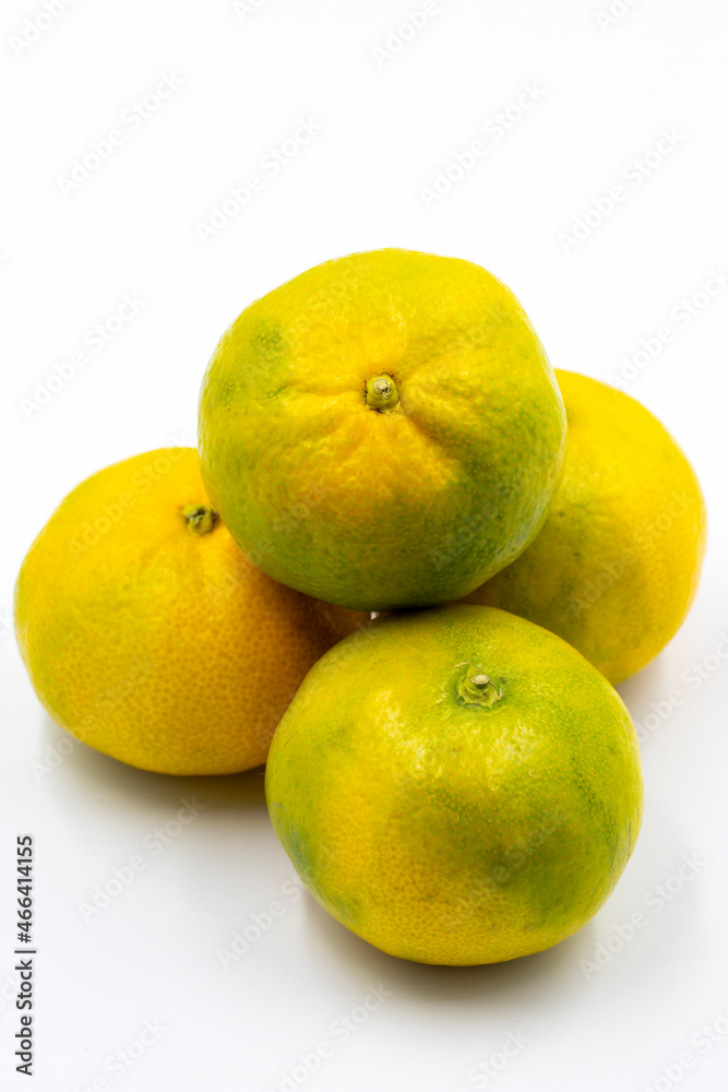 Tangerines on a white background. In combination with a shade of ripe sweet tangerine. Story format close-up