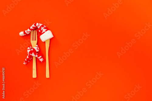  The creative concept of a festive menu mockup, diet, natural healthy food one red background. Wooden cutlery. Background for christmas,New Year lunch, dinner invitation or party with copy space