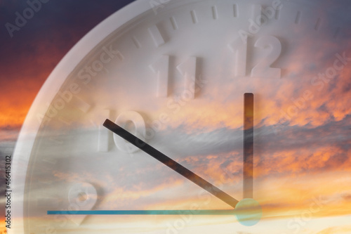 Cloudy sunset sky and close up of clock. Double exposure. Daylight Savings Time Concept