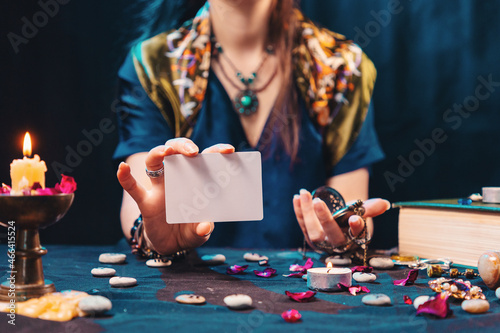 Magic and esotirism concept. The fortune teller shows an empty white tarot card. Mock up. Cartomancy and fortune telling photo
