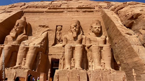 4K footage of the huge Abu Simbel temple with the statues of gods and Ramses II with many tourists visiting it at sunrise time. Concepts of tourism industry, ancient monuments and travel to Egypt. photo