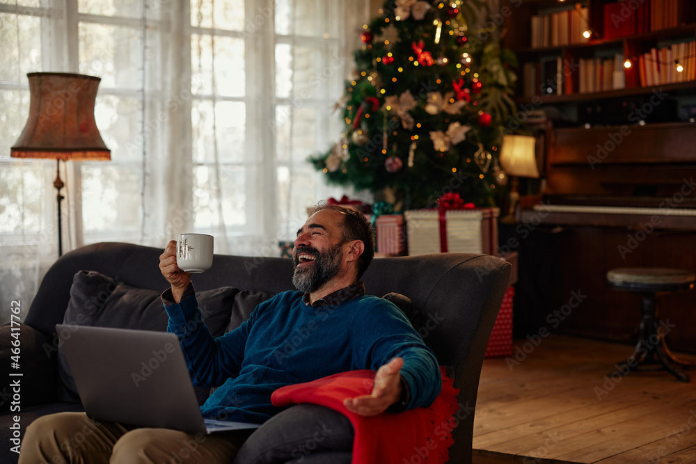 Middle age man having video call during Christmastime