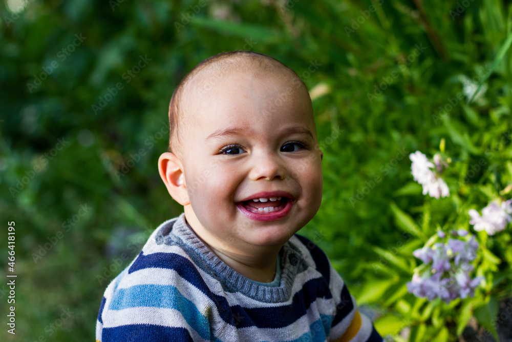 Cute little baby boy outdoors. Happy smiling baby at green garden Cute little baby boy outdoors. Happy smiling baby at green garden