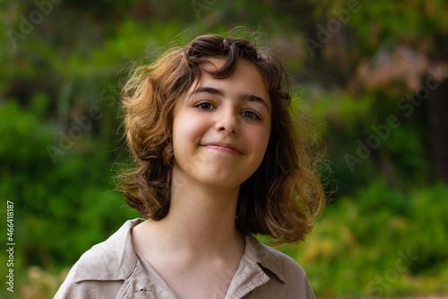 Cute teenager girl smiling to camera. Young girl in the forest