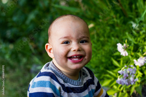 Cute little baby boy outdoors. Happy smiling baby at green garden