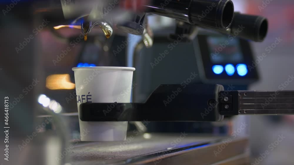 Close-up of coffee machine pours beverage in the cup.