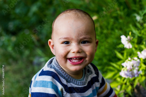Cute little baby boy outdoors. Happy smiling baby at green garden
