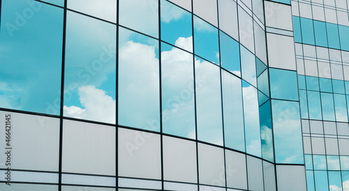 business building in city with mirror windows with reflections of blue sky.