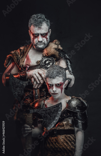 Fototapeta Naklejka Na Ścianę i Meble -  Military family a father and son armed with axes in studio