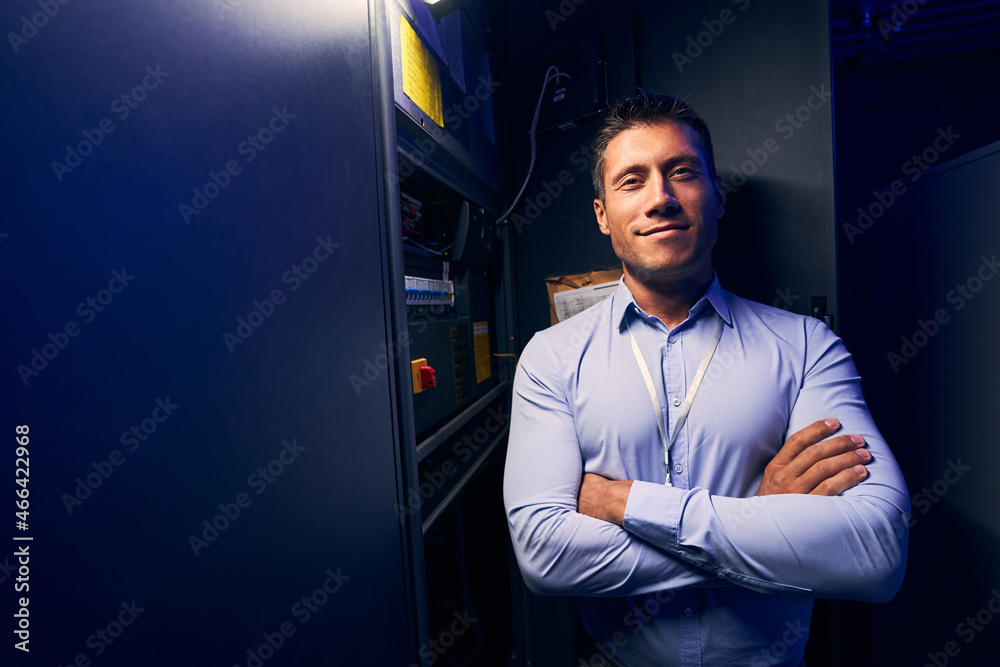 Contented data center employee smiling at camera Contented data center employee smiling at camera
