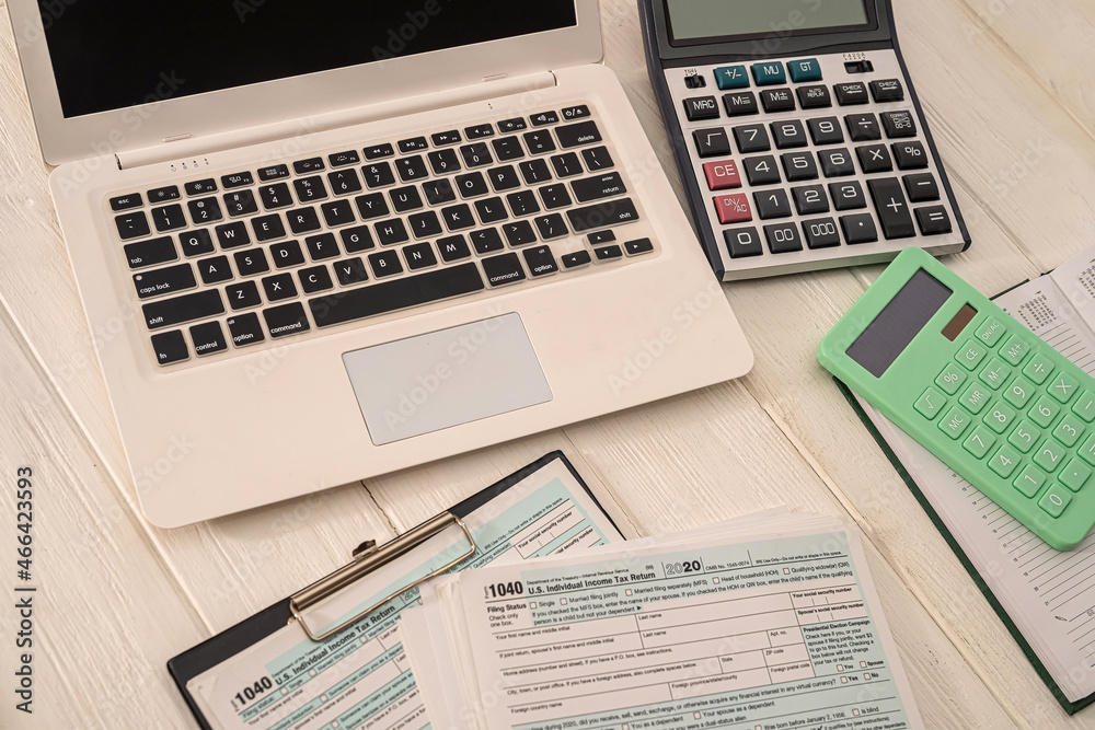 new laptop two calculators and blank blank tax form usa 1040 with tablet lying on the table new laptop two calculators and blank blank tax form usa 1040 with tablet lying on the table