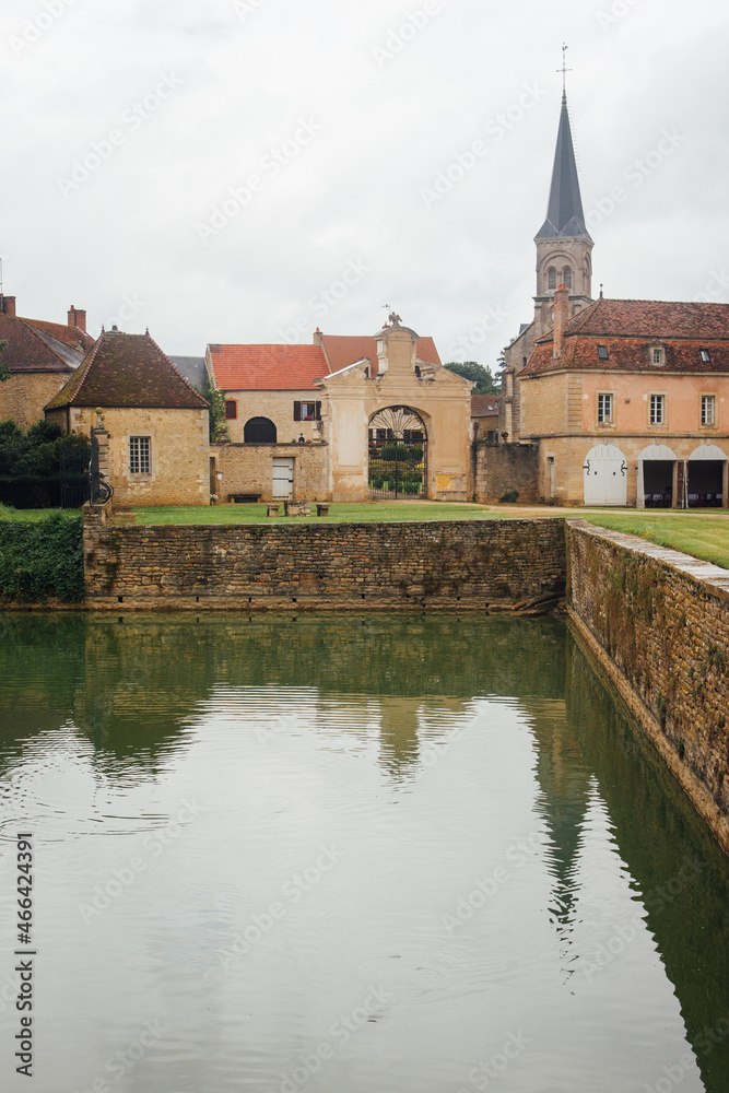 Le reflet d'un village dans un étang. Un village français. Le village de Commarin.