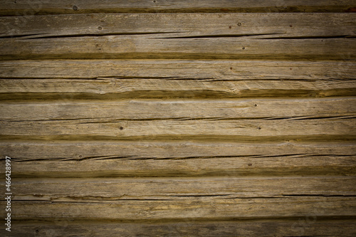 Wooden logs of an old house. Close-up. Weathered natural gray wood texture. Background. Horizontal photo
