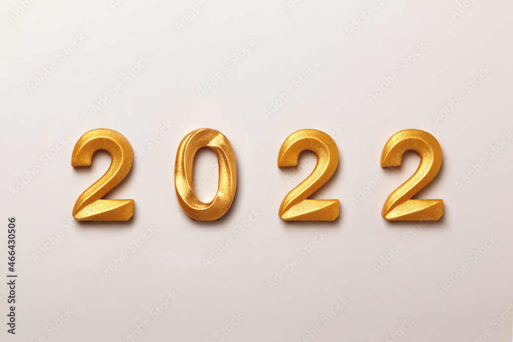 New Year composition with the inscription 2022 gold-colored numbers on a white background. New Year composition with the inscription 2022 gold-colored numbers on a white background.